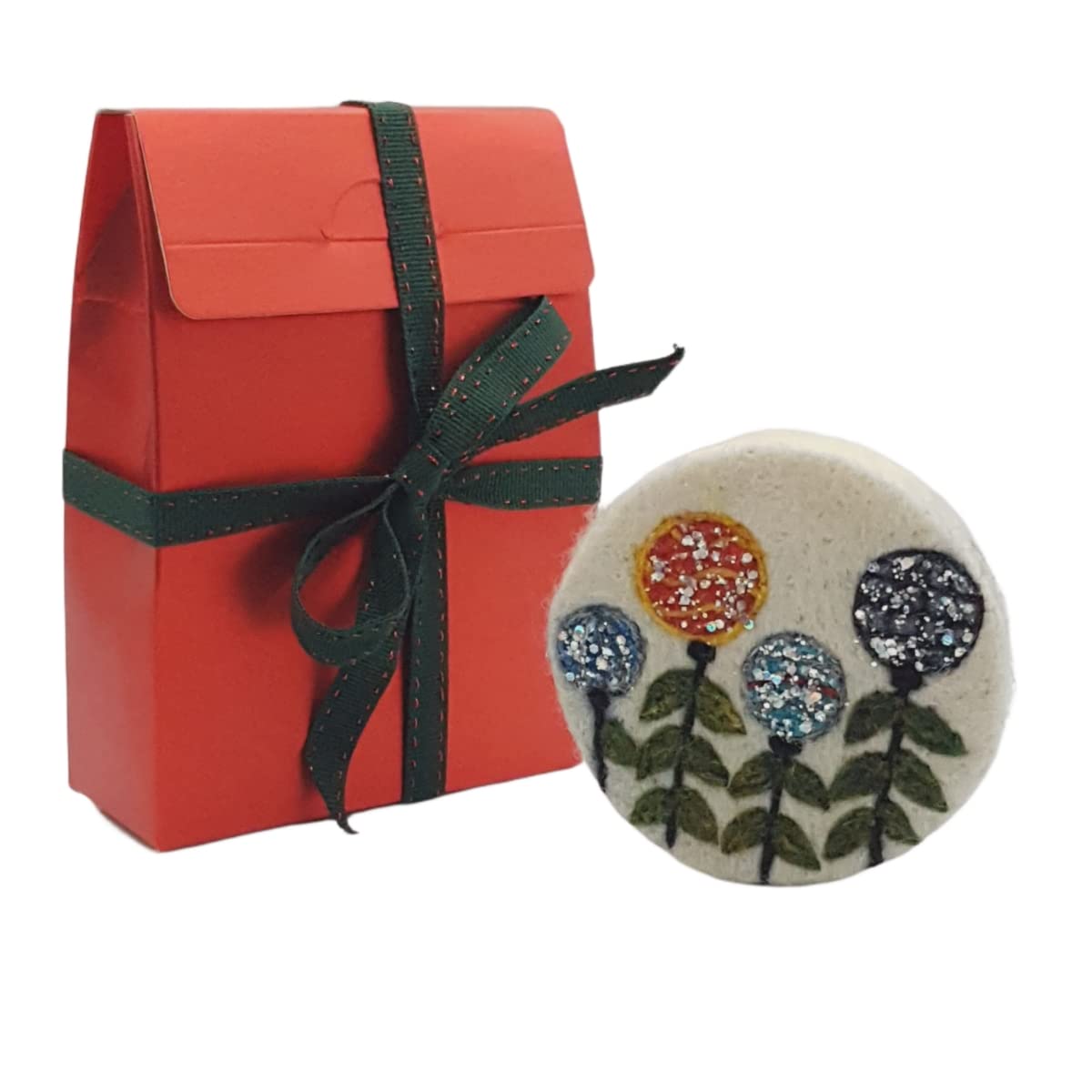 Red gift box with green ribbon and a decorative flower pin on a white background
