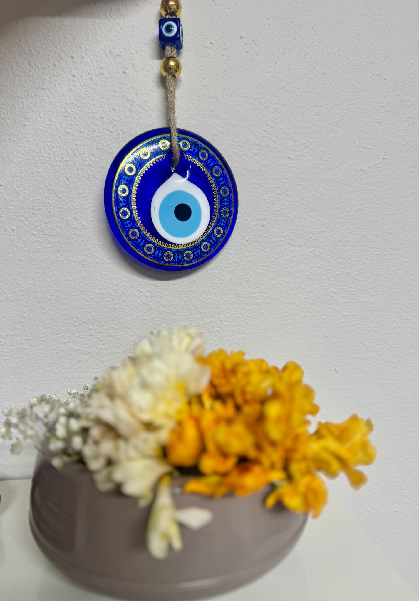 Decorative evil eye pendant with flowers on a white background