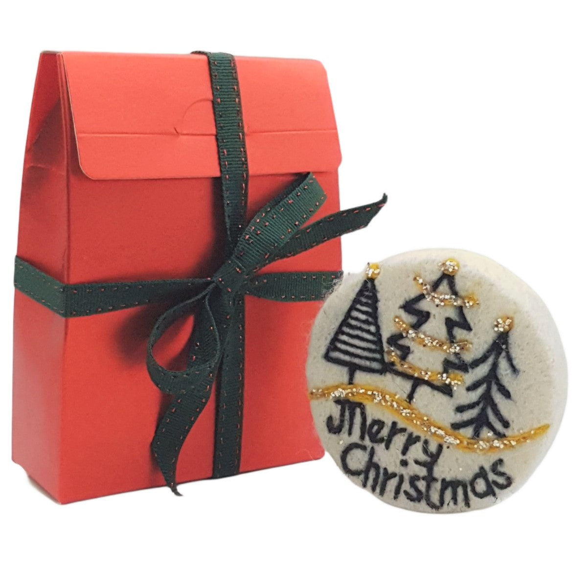 Red gift box with green ribbon and a round Christmas-themed item on a white background