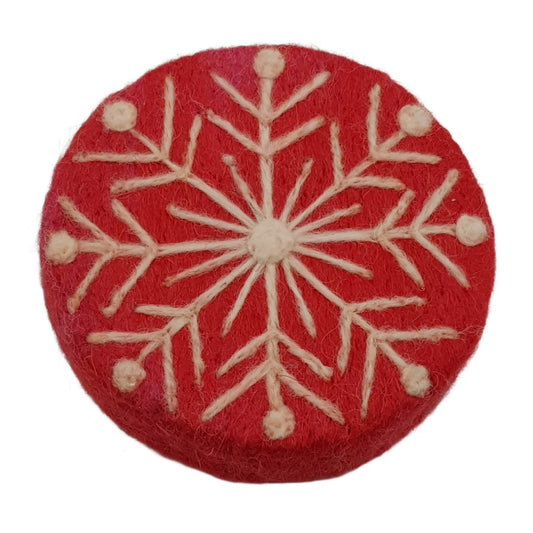 Red circular fabric patch with white snowflake pattern on a white background