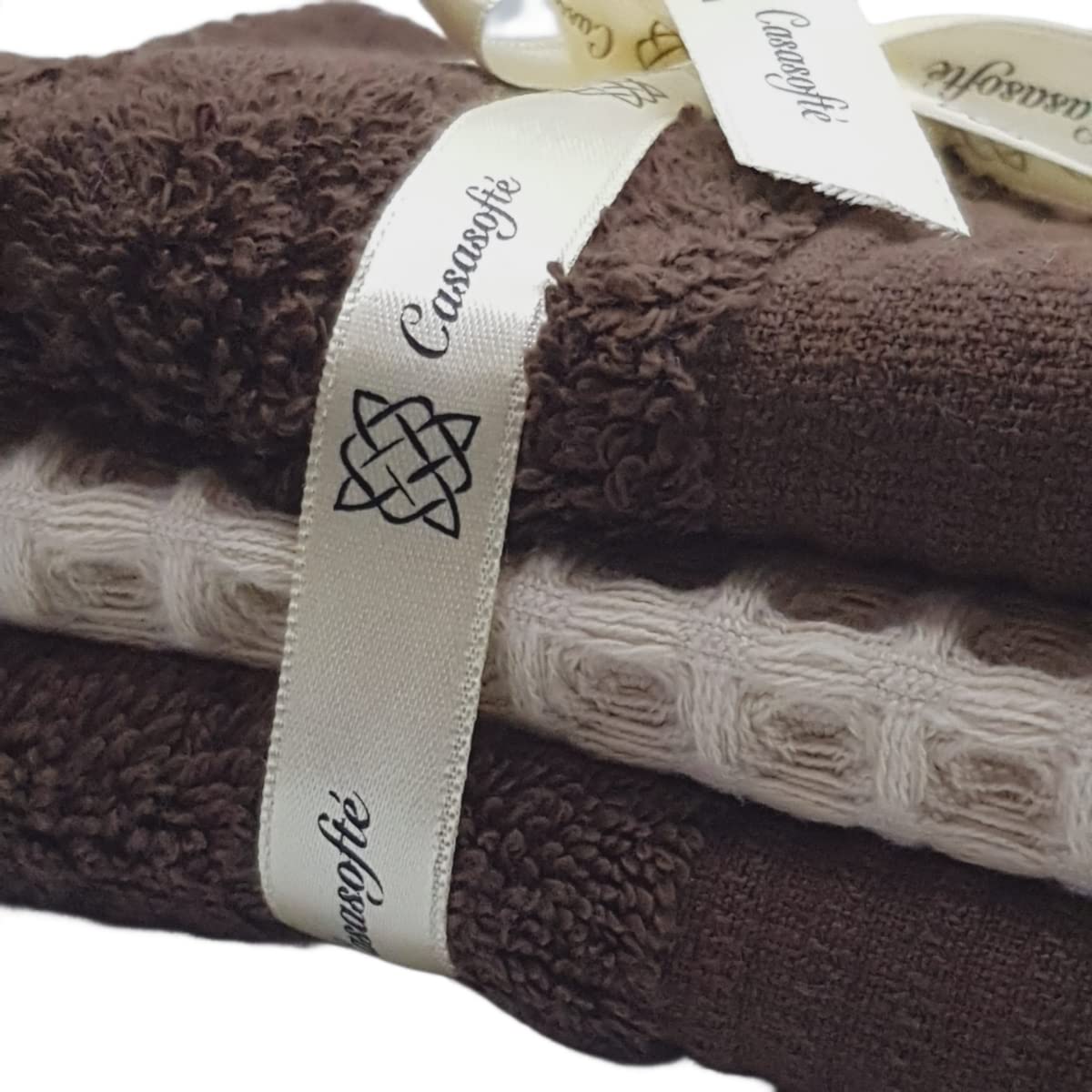 Stack of brown towels with a Casamode label on a white background