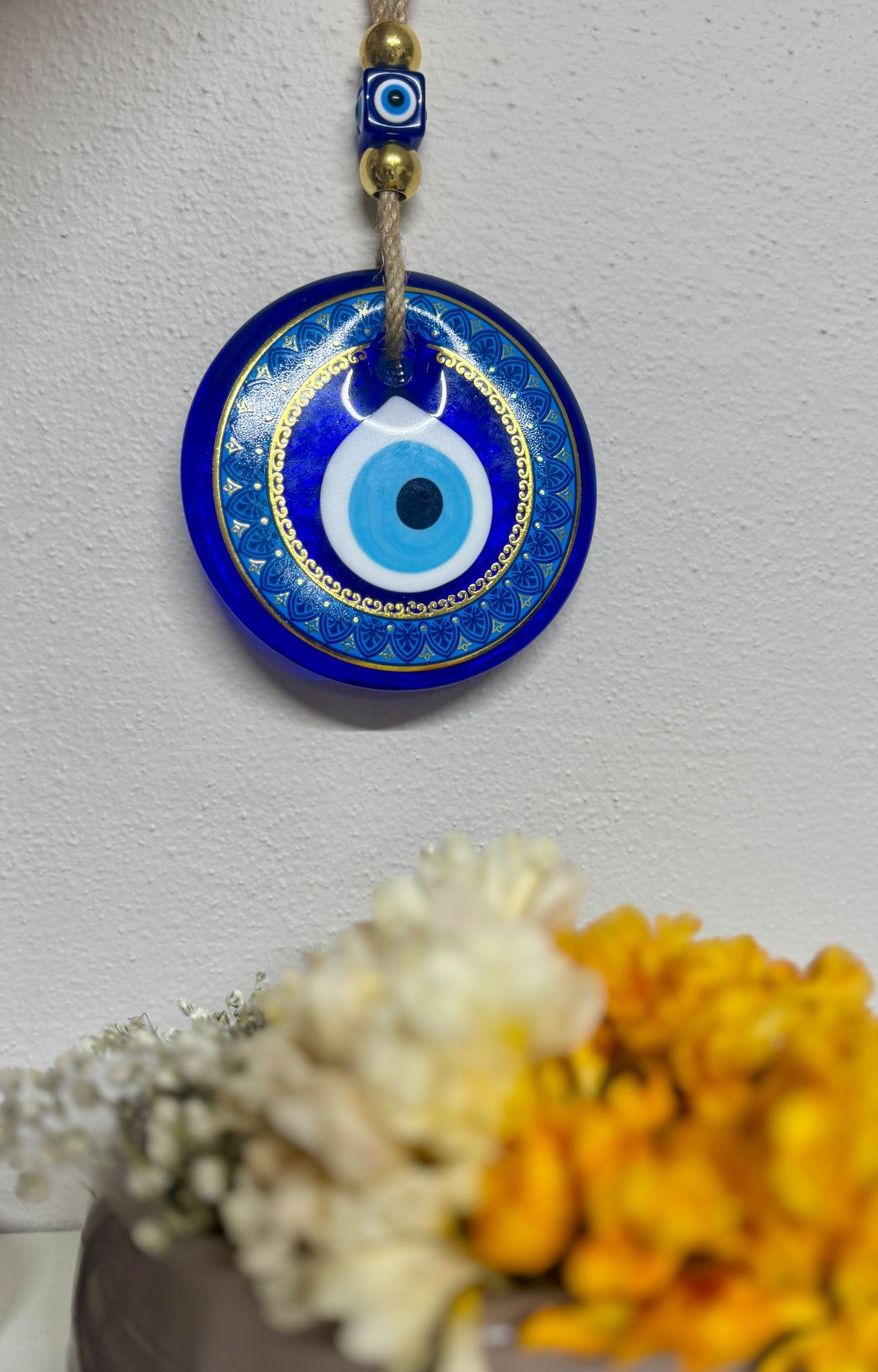 Blue evil eye pendant with gold accents on a white background